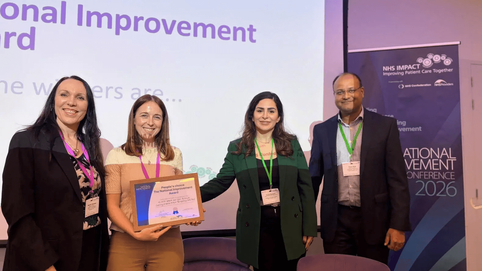 An image of a person being presented an award on behalf of their trust at the NHS IMPACT event.