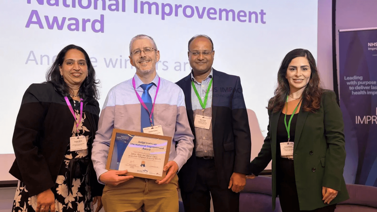 An image of a person being presented an award on behalf of their trust at the NHS IMPACT event.