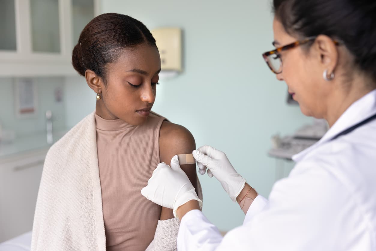 Doctor or nurse giving a young person a vaccination